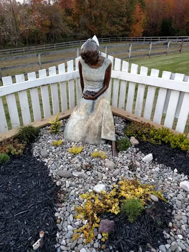 Serene garden statue surrounded by stones at Wellness House of Annapolis, a sober living home in Maryland.