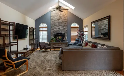 Spacious living room with stone fireplace at Bay Homes Sober Living, a sober living home in Maryland.